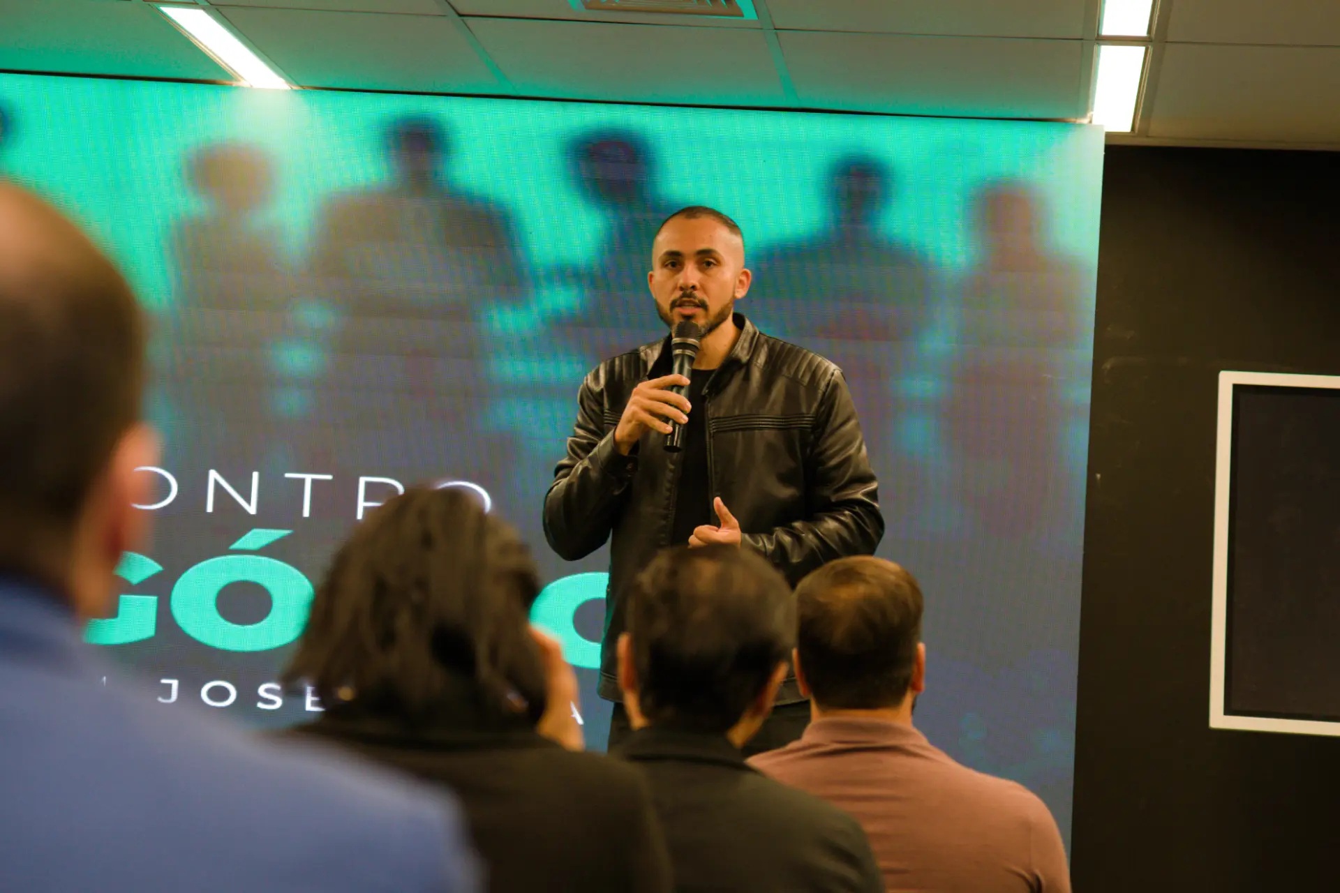 Diego Oliveira palestrando em um evento presencial para empresários e especialistas